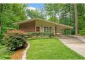 Charming brick home with a well-manicured lawn, lush landscaping, and attached covered parking at 1103 Lee Ne Cir, Atlanta, GA 30324