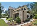 Elegant brick home featuring meticulous landscaping and a covered entryway with dark trim at 477 Michael Dr, Alpharetta, GA 30009