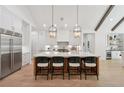 Open-concept kitchen featuring a large island with seating, stainless steel appliances and hardwood floors at 477 Michael Dr, Alpharetta, GA 30009