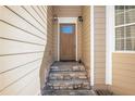 Inviting front entrance featuring a wood door, stone steps, and sconce lighting at 915 Pebble Creek Trl, Suwanee, GA 30024