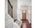 Elegant entryway with hardwood floors, staircase with iron spindles, and paneled walls at 915 Pebble Creek Trl, Suwanee, GA 30024