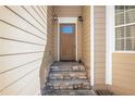 Inviting front entrance with stone steps leading to a wood door with sidelights and decorative sconces at 915 Pebble Creek Trl, Suwanee, GA 30024