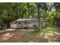 Single-story home with a welcoming front porch and mature trees surrounding the property at 303 Nottingham Dr, Woodstock, GA 30188