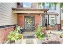 Inviting front porch with brick accents, decorative plants, and a welcoming wreath on the front door at 312 Sierra Ct, Mcdonough, GA 30253