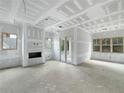 Unfinished living room featuring abundant natural light, a fireplace, and access to the outdoors at 60 Linton St, Woodstock, GA 30188