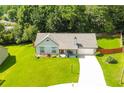 A well manicured lawn and single story home surrounded by lush trees at 787 Mckendree Lake Way, Lawrenceville, GA 30043