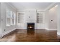 Inviting living room featuring hardwood floors, a fireplace, and built-in bookcases flanking a window at 1836 Preserve Way, Brookhaven, GA 30341