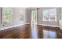 Spacious living room with hardwood floors, three windows, and sliding doors to outdoor deck at 1836 Preserve Way, Brookhaven, GA 30341