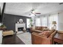 Cozy living room with a decorative fireplace, large windows, and comfortable brown leather sofas at 306 Overbend Sw Lndg, Marietta, GA 30008