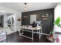 Home office features a dark accent wall with floating shelves, desk and modern pendant lighting at 306 Overbend Sw Lndg, Marietta, GA 30008