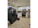 Efficient kitchen with white cabinets, stainless steel oven, and black refrigerator at 616 Burnt Creek Nw Way, Lilburn, GA 30047