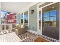 Charming front porch with wicker seating, brick floor, and a welcoming entrance at 164 Palm St, Holly Springs, GA 30188