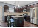 Modern kitchen with stainless steel appliances, dark wood cabinets, and center island at 4746 Highland Ave, Sugar Hill, GA 30518