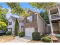 Side view of a charming two-story home with brick facade and attached one-car garage at 6341 Lake Valley Pt, Lithonia, GA 30058