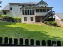 A view of a level, grassy backyard, a small deck, and the rear exterior of the house at 710 Larkspur Nw Blvd, Acworth, GA 30102