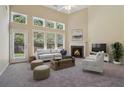 Bright living room with tall windows, a cozy fireplace, and plush seating arrangement at 1755 Rutland Pass Dr, Lawrenceville, GA 30045