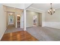 Inviting open-concept living area with neutral paint, modern chandelier, carpeted floors and wood accents at 1755 Rutland Pass Dr, Lawrenceville, GA 30045