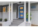 Stylish covered front porch with a bright blue front door, white pillars, and brick accents at 2463 Briarmoor Ne Rd, Atlanta, GA 30345