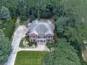 An aerial view of the brick home featuring mature trees, landscaping and a long driveway at 4450 Barony Dr, Suwanee, GA 30024