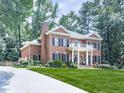 Traditional brick home with a lush front yard, long driveway, side garage and mature shade trees at 4450 Barony Dr, Suwanee, GA 30024