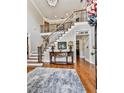 Spacious foyer with hardwood floors, a staircase with wrought iron railings, and elegant decor at 4450 Barony Dr, Suwanee, GA 30024
