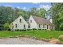 Inviting home showcasing a lush front lawn and a quaint stone retaining wall, enhancing curb appeal at 5095 Karr Road Rd, Cumming, GA 30040
