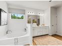 Bright bathroom featuring a soaking tub, spacious vanity, and a large window providing natural light at 817 Dobby Way, Mcdonough, GA 30252