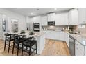 Modern kitchen featuring white cabinets, granite countertops, stainless steel appliances, and a center island with barstool seating at 817 Dobby Way, Mcdonough, GA 30252