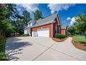 Spacious two-car garage with a long driveway and mature trees providing ample shade at 205 Finsbury Park Ct, Suwanee, GA 30024