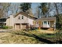 View of home with attached garage on large lot surrounded by mature trees and shade at 494 Rue Montaigne, Stone Mountain, GA 30083