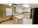 Bright kitchen with white cabinets, tiled floors, and new stainless steel gas range at 494 Rue Montaigne, Stone Mountain, GA 30083