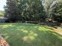 Spacious backyard featuring a well-maintained lawn and mature trees for privacy at 545 Ashvale Overlook, Alpharetta, GA 30005