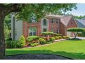 Attractive brick home with lush green lawn and mature landscaping at 545 Ashvale Overlook, Alpharetta, GA 30005