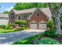 Charming brick home featuring a two-car garage and landscaped front yard at 545 Ashvale Overlook, Alpharetta, GA 30005