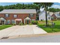 View of attractive brick townhome with large driveway and well-maintained landscaping at 3665 Magnolia Walk Trl, Cumming, GA 30040