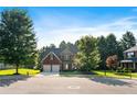 Beautiful two-story brick home with a two-car garage surrounded by mature trees and a well-manicured lawn at 1496 Clarecastle Ln, Buford, GA 30519