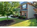 Side view of a well-maintained two-story brick home, showing manicured landscaping and green lawn at 1496 Clarecastle Ln, Buford, GA 30519