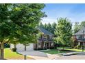 Attractive two-story brick home with a two-car garage, lush greenery, and a well-maintained lawn at 1496 Clarecastle Ln, Buford, GA 30519