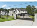 Elegant two-story home with white brick, black trim, gated entrance, and a professionally landscaped yard at 3205 Bold Springs Rd, Dacula, GA 30019