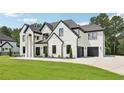 Beautiful two-story home with a white brick facade, dark trim, attached garage, and meticulously kept lawn at 3205 Bold Springs Rd, Dacula, GA 30019