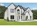 Handsome two-story house showcasing painted brick, black trim, an arched entrance, and a lush green lawn at 3205 Bold Springs Rd, Dacula, GA 30019