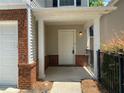 Inviting covered front porch featuring brick accents and a freshly painted front door at 646 Lakes Cir, Lithonia, GA 30058