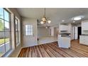 Sunlit breakfast area with large windows, pendant lighting, and hardwood floors at 145 Charleston Pl, Covington, GA 30016