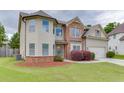 Charming two-story home featuring a manicured lawn, brick accents, and an attached two-car garage at 1548 Station Ridge Dr, Lawrenceville, GA 30045