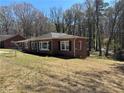 View of a brick house with black shutters surrounded by a lawn at 2103 River Rd, Ellenwood, GA 30294