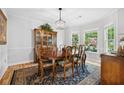 Elegant dining room with hardwood floors, wainscoting, and natural light from bay windows at 908 Lance Cir, Lawrenceville, GA 30043