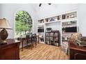 Bright study with large arched window, custom built-in shelving, and hardwood floors at 908 Lance Cir, Lawrenceville, GA 30043