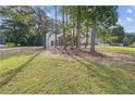Picturesque lot with mature trees surrounding the home and a lush green lawn at 4000 Brittan Glade Trl, Snellville, GA 30039