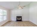 Bright living room features beautiful floors, fireplace and a modern ceiling fan at 125 Ashbury Ct, Dallas, GA 30157