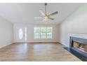 Light-filled living room features high ceilings, fireplace, luxury vinyl flooring and a front door at 125 Ashbury Ct, Dallas, GA 30157